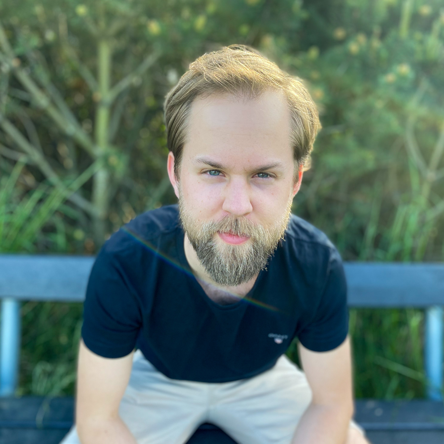 Ett fotografi av en man i 30-årsåldern med keps som håller armen runt en brunhårig kvinna med uppsatt hår och glasögon. I bakgrunden syns en fårhage.